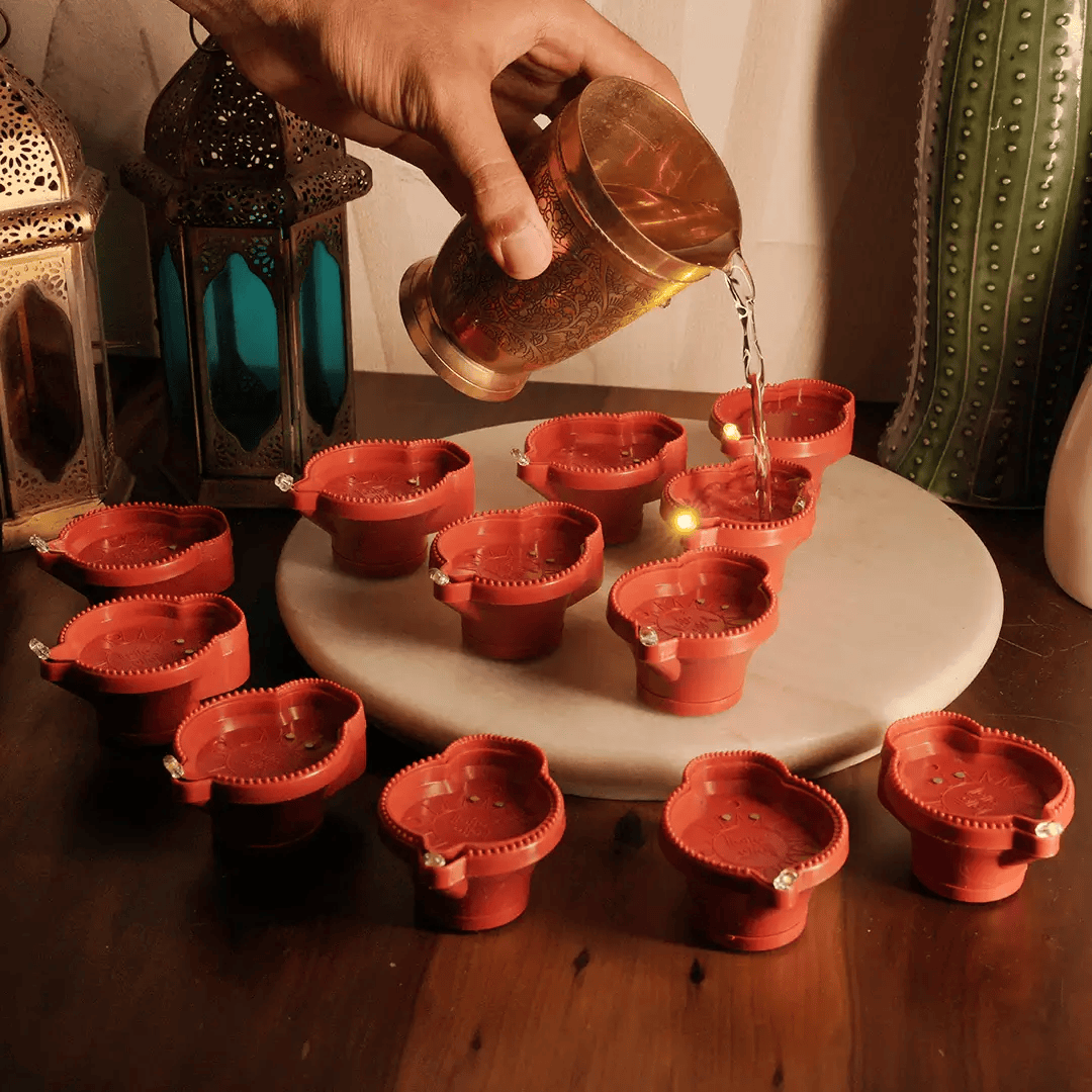 Water Sensor LED Diya collection glowing on a decorative table with lanterns and plants.